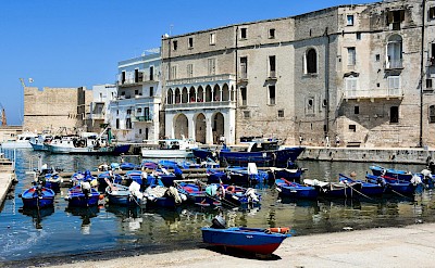 Colorful fishing boats rest in the historic old port in Monopoli. Pexels@AXPphotograghy