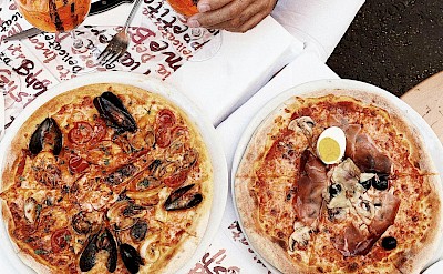 Fresh seafood pizzas and aperitifs served al fresco. pexels@Shvets Production