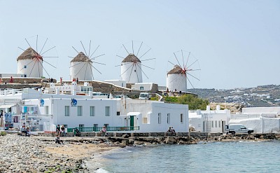The famous Mykonos windmills overlooking the waterfront and the Aegean Sea. pexels@Diego F Parra
