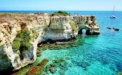 Dramatic limestone cliffs and crystal-clear water along the Salento coast. unsplash@MassimoVirgilio