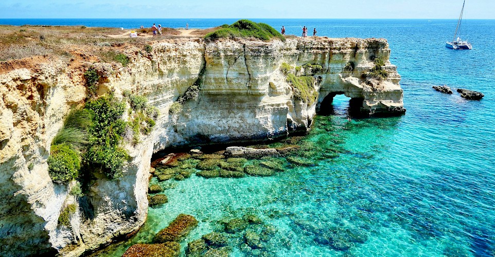 Dramatic limestone cliffs and crystal-clear water along the Salento coast. unsplash@MassimoVirgilio