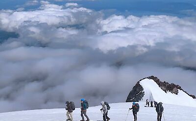 Standing above the clouds on Argentina to Chile bike tour. toAT