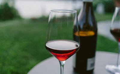 Glass of wine overlooking the lakeshore. unsplash@yianni-mathioudakis