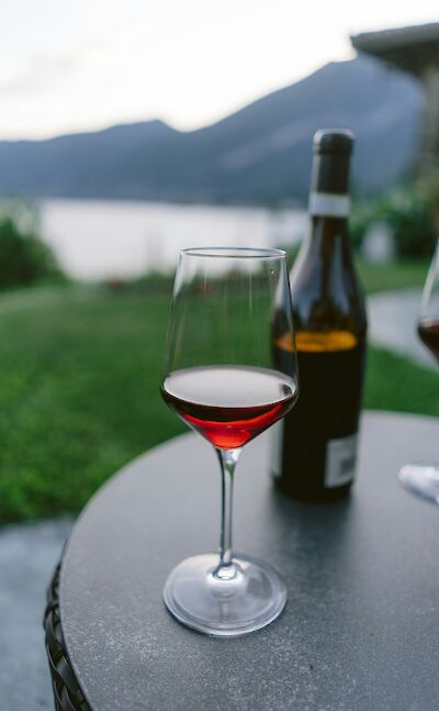 Glass of wine overlooking the lakeshore. unsplash@yianni-mathioudakis