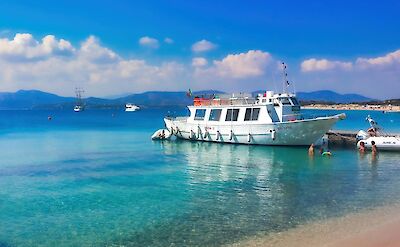 A boat docked in the clear turquoise waters of Sardinia. pexels@DomenicoAdornato