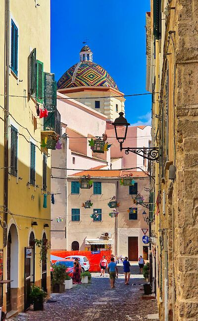 Historic street in Alghero's old town with views of the Cathedral of Santa Maria. pexels@DomenicoAdornato