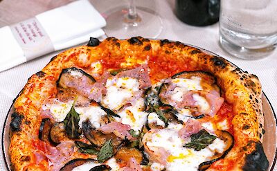 Wood-fired pizza and a glass of wine. Pexels@Emilianovittoriosi