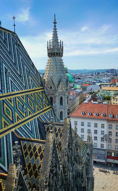 Intricate patterned tile roof and stone spire of St. Stephen's Cathedral, Vienna, Austria. Unsplash@Victor Malyushev