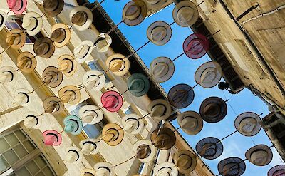 Colorful hats decorating a street in Avignon. unsplash:Studimajo