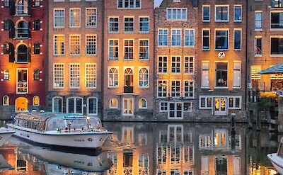Historic canal houses glow at dusk in Amsterdam. Pixabay:Lubovlisitsa