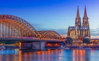Cologne Cathedral and the Hohenzollern Bridge illuminated at dusk. to:TN
