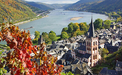 View over the UNESCO Rhine Gorge with vineyards, riverboats, and historic villages. to:TN