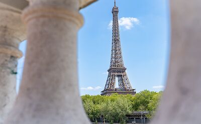 The Eiffel Tower framed by stone columns in Paris. toTN