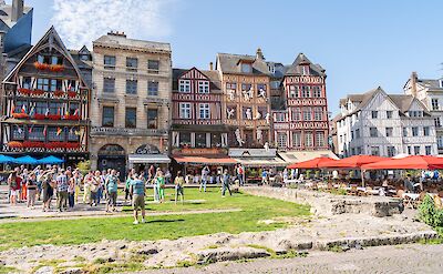 Rouen, France, surrounded by historic half-timbered buildings and outdoor cafe seating. toTN