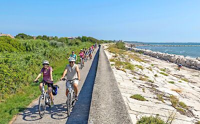 Cycling along a narrow waterfront path. toGL