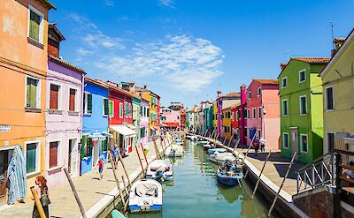 Brightly painted houses and fishing boats along Burano's canals. unsplash:TjaardKrusch