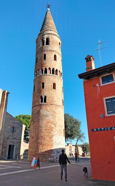Historic bell tower and colorful buildings in Caorle, Italy. cc:to