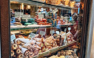 Traditional Italian pastries and sweets displayed in a bakery window. pexels:AlinaKomarevska