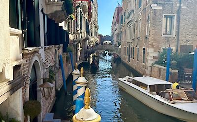 Narrow canal lined with historic buildings in Venice. cc:Tripsite