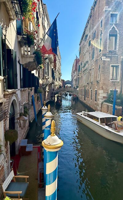 Narrow canal lined with historic buildings in Venice. cc:Tripsite