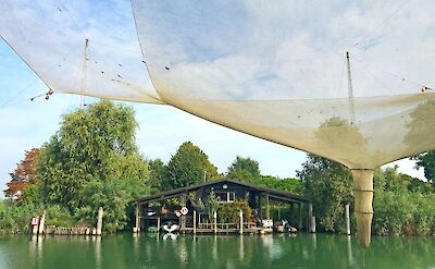Traditional fishing nets and wooden structures along the lagoon waterways. cc:to