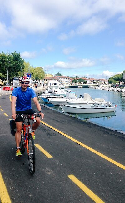 Cyclists riding along a waterfront bike path in northeastern Italy. cc:to