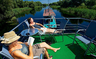Sunning on the hotel boat. Danube Delta Bike Tour in Romania. Photo via TO