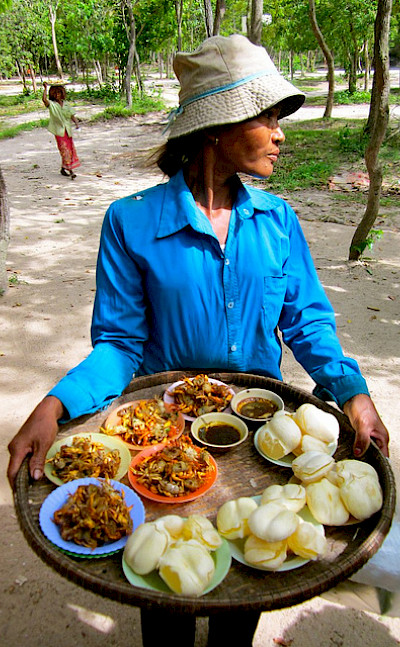 Cambodian woman selling food. Photo via Flickr:flickingerbrad