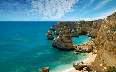 Lagos, Portugal. Great views from the bike of the gorgeous blue waters against towering cliffs. Photo via Wikimedia Commons:Ricard12