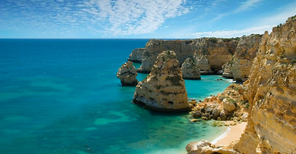 Lagos, Portugal. Great views from the bike of the gorgeous blue waters against towering cliffs. Photo via Wikimedia Commons:Ricard12