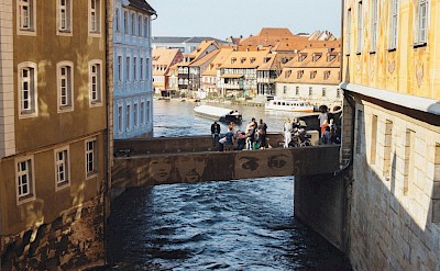 Pedestrians crossing a bridge in Bamberg, Germany. Unsplash@Lukas D