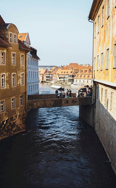 Pedestrians crossing a bridge in Bamberg, Germany. Unsplash@Lukas D