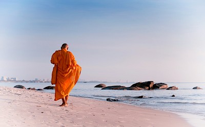 Monk on the beach in Hua Hin, Thailand bike tour. Unsplash@Thomas Oxford