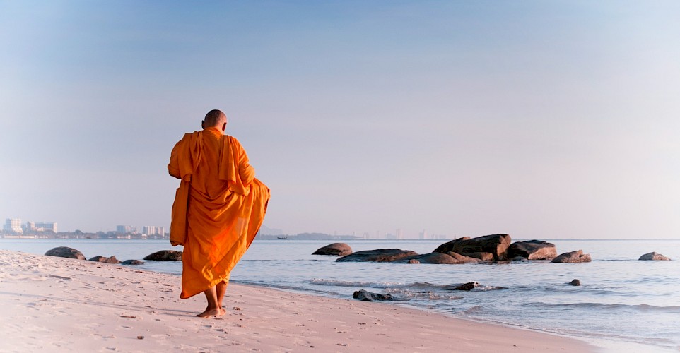Monk on the beach in Hua Hin, Thailand bike tour. Unsplash@Thomas Oxford