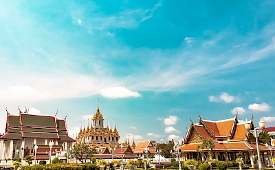 Blue skies over temples in Bangkok, Thailand bike tour. Unsplash@Alejandro Cartagena