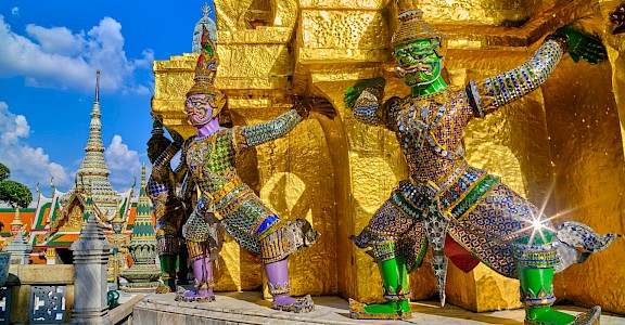 Gleaming gold temple with colorful sculptures in Bangkok, Thailand bike tour. Unsplash@Worachat Sodsri