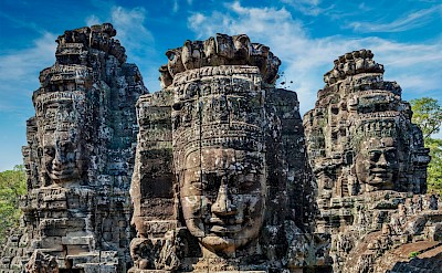 Huge faces in the stone at Angkor Wat, Cambodia bike tour. Unsplash@Getty Images