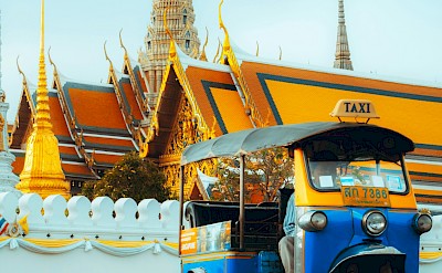 Tuk tuk parked outside a temple in Bangkok, Thailand bike tour. Unsplash@Mos Sukjaroenkraisri Shop