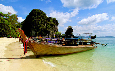 Boats on a beach await in Phuket, Thailand. Flickr:Jeff Gunn