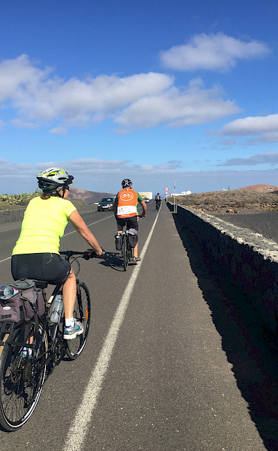 Mary and group cycling the scenic lava-covered volcanic island of Lanzarote, Canary Islands, Spain.