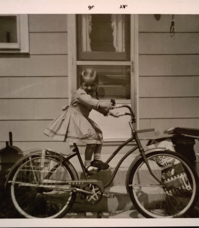 Old picture of girl on bike.