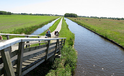 Cycling along the canal in Giethoorn, Overijssel, the Netherlands. Flickr:Oscar Vilaplana