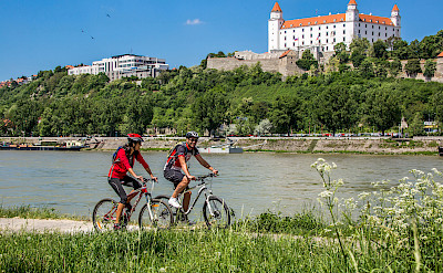Cycling past Bratislava Castle in Slovakia along the Danube River bike tour. ©TO