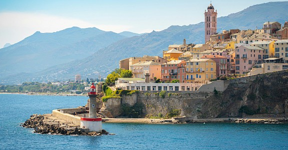 A panoramic view of Bastia’s colorful Old Town and its iconic lighthouse. unsplash@PetrSlovacek