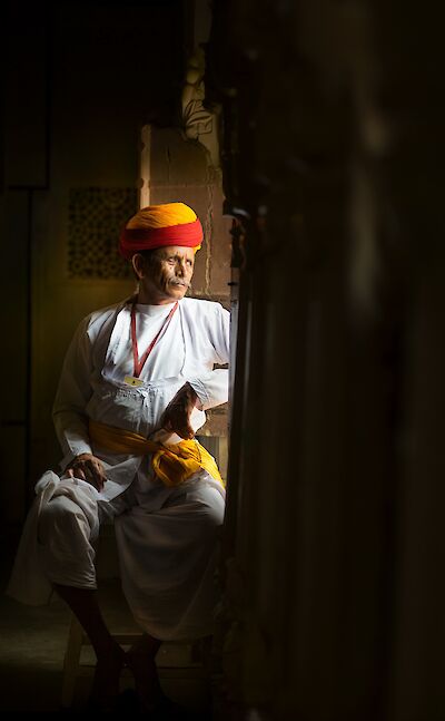Local man looking out of the window of a palace, Udaipur. Unsplash@Aditya Siva