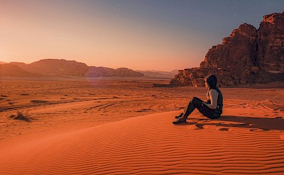 Woman sitting in Wadi Rum desert, Jordan. Unsplash@Daniele Colucci