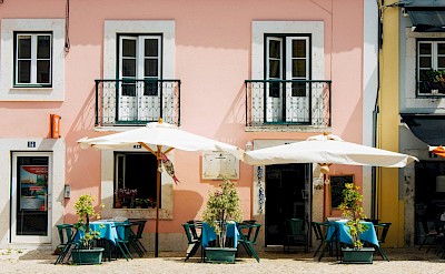Chairs outside a pink building in Lisbon, Portugal. Unsplash@Clifford