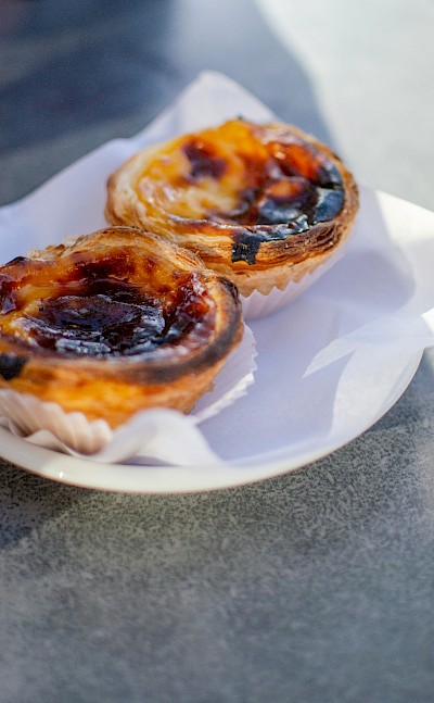 Plate of fresh pasteis de nata, Portugal. Unsplash@Hector John Periquin