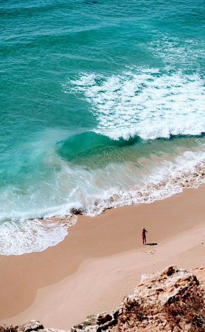 Woman standing on the beach, Sagres, Portugal. Unsplash@Micaela Parente