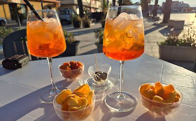 Golden hour aperitivo with Aperol Spritz and snacks in Sicily. pexels:IlmaElsberga